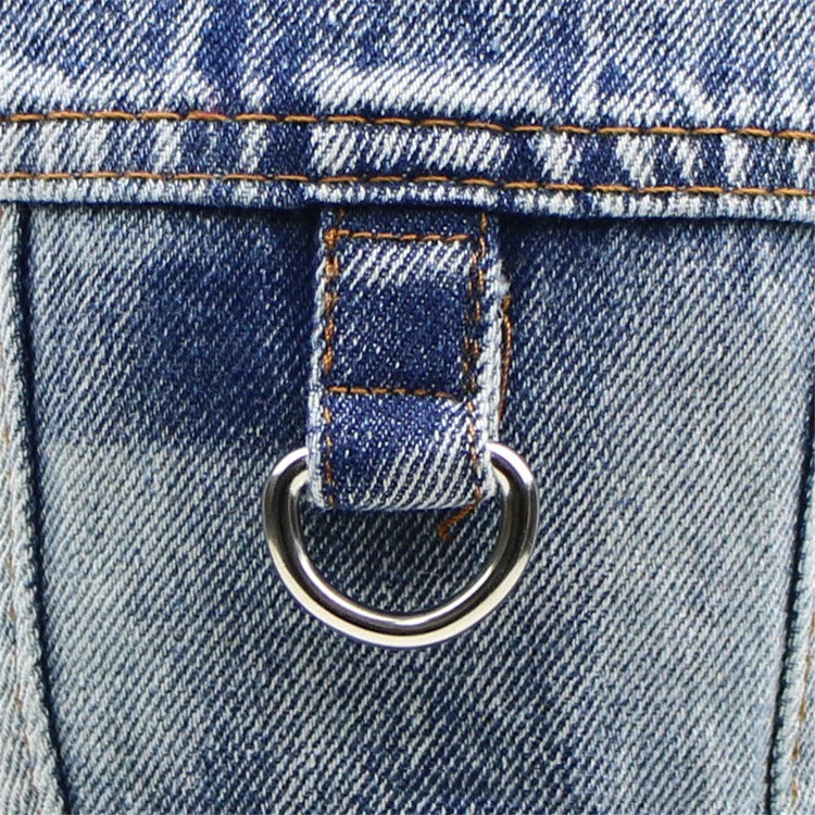 Close-up of a blue denim fabric with a metal ring detail