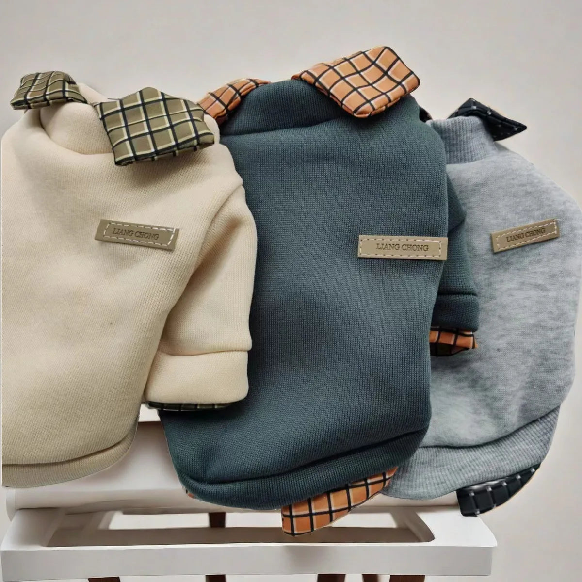 Three dog coats in beige, blue, and gray on a white surface with 'Karma Couture' branding.