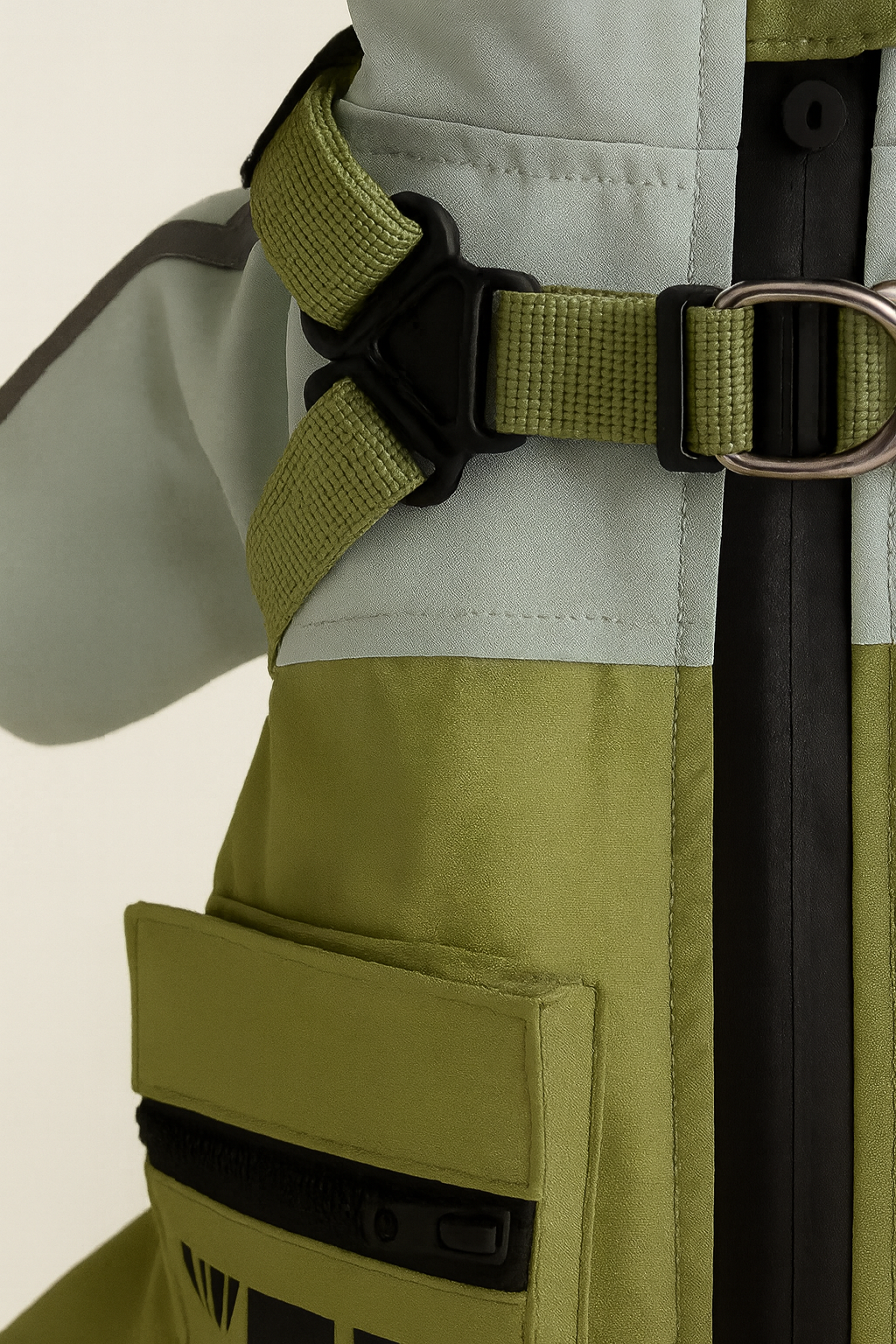 Close-up of a green tactical vest with a strap on a beige background